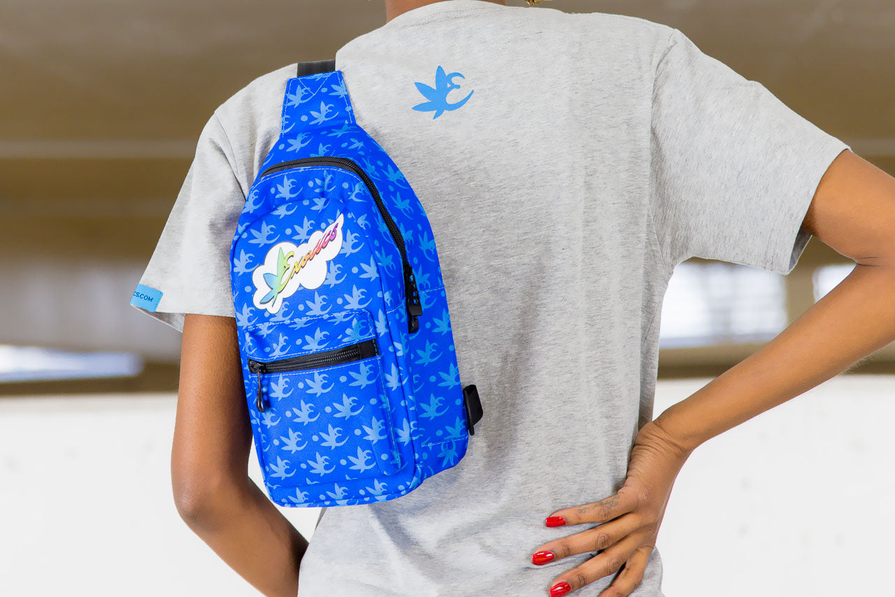 Model wearing blue Exotics crossbody shoulder bag with rainbow logo