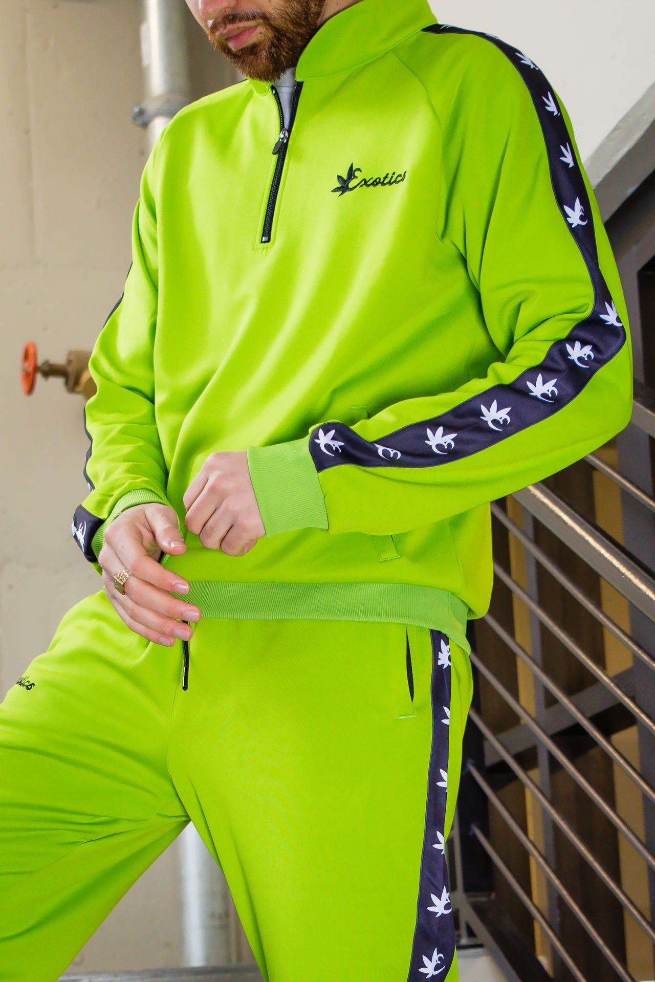 Man wearing green Exotics tracksuit with black details