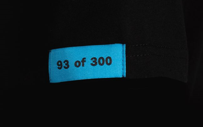 Blue sleeve tag on black Exotics Jason tee t-shirt