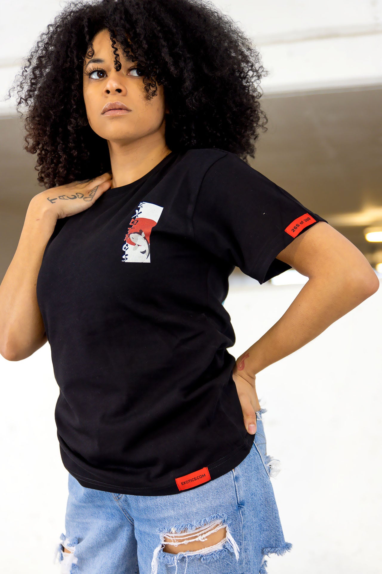 Woman wearing black Exotics tee t-shirt with koi fish design on front